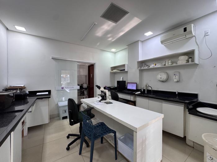 Área técnica do laboratório com microscópio e bancadas