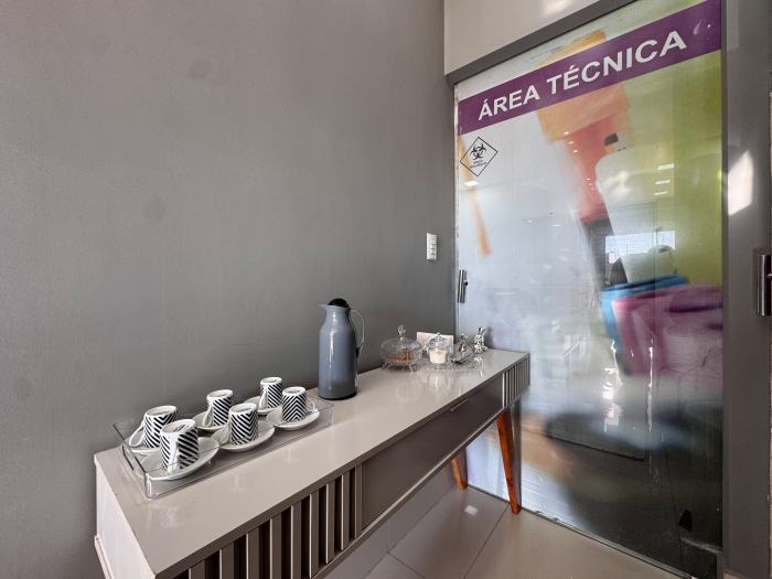 Aparador com café e xícaras ao lado da porta da área técnica