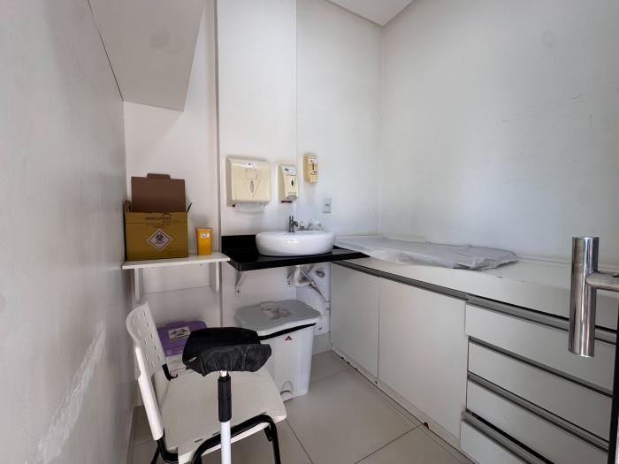 Sala de coleta com cadeira, pia e bancada forrada
